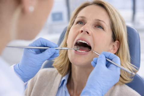 Dentist examining early cavity signs in patient without tooth pain in Whittier CA