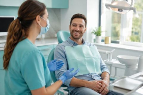 Dentist giving aftercare advice to a smiling patient about how long after a filling you can eat in Whittier CA
