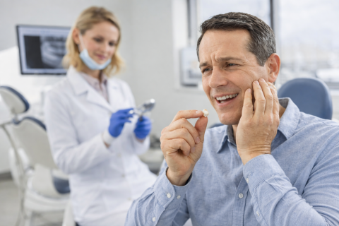 Man holding lost dental crown with tooth pain at dentist office in Whittier CA